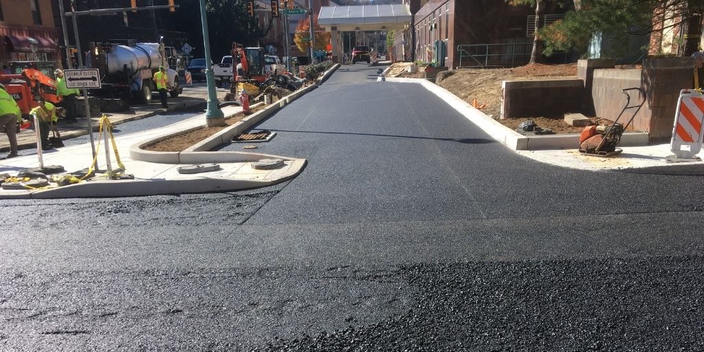 Freshly paved road in Johnstown PA with construction ongoing in the background.